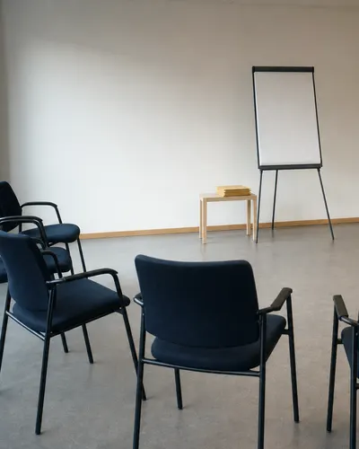 KI-generiertes Bild: Stuhlhalbkreis in einem hellen Seminarraum